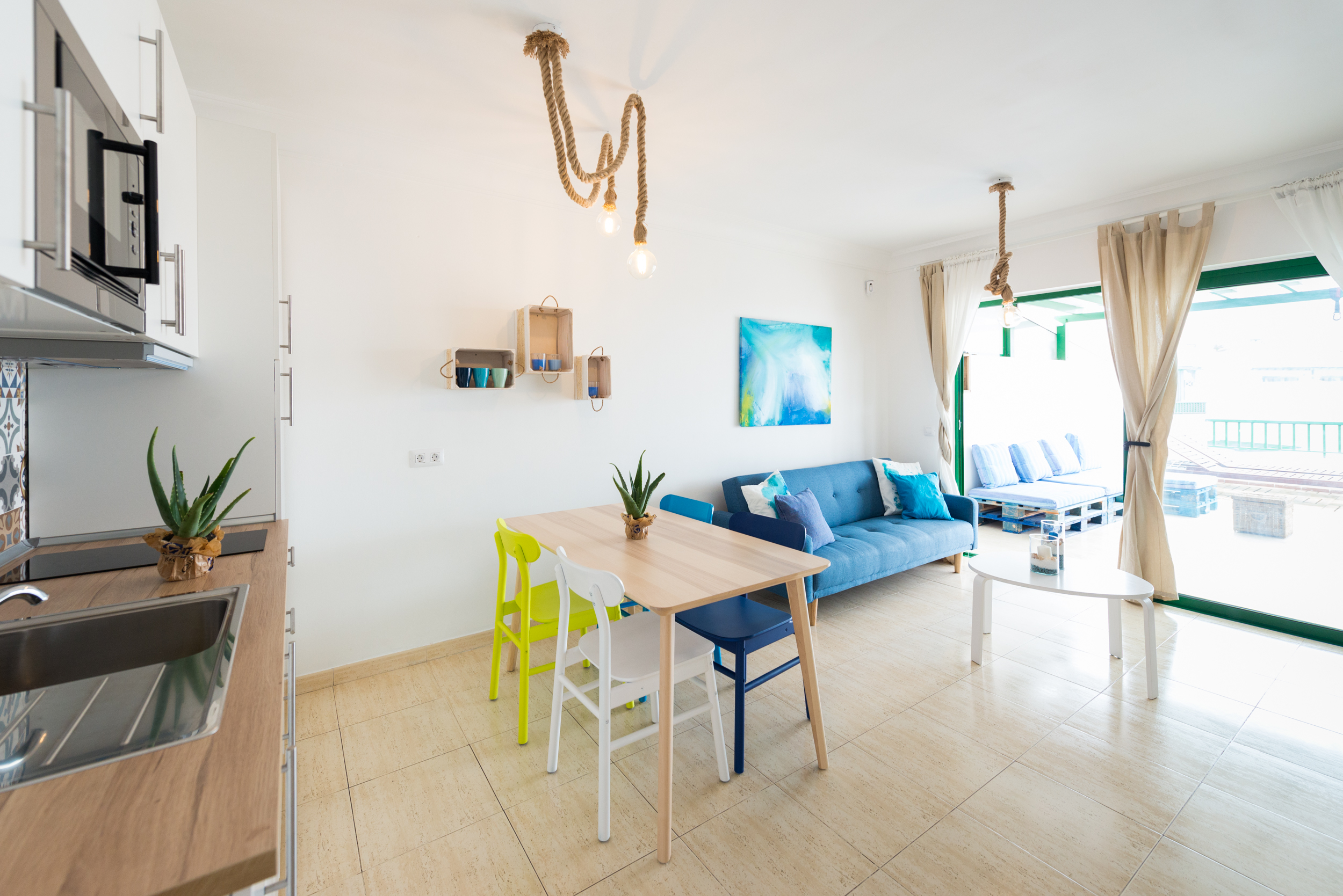 Kitchen view showing hob, sink and open living space leading to the terrace