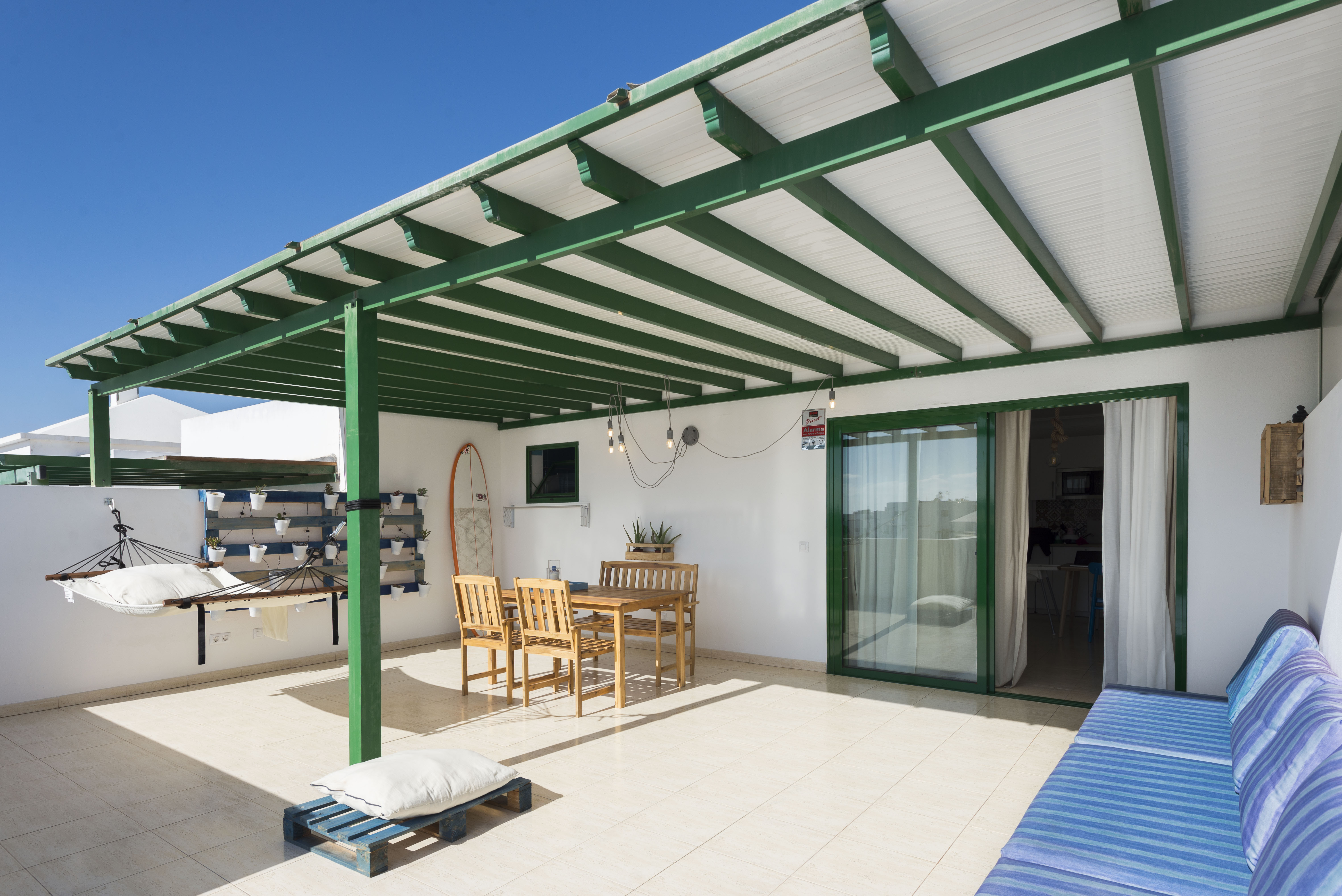 Full rooftop terrace of La Siesta Azul with green pergola, hammock and outdoor dining