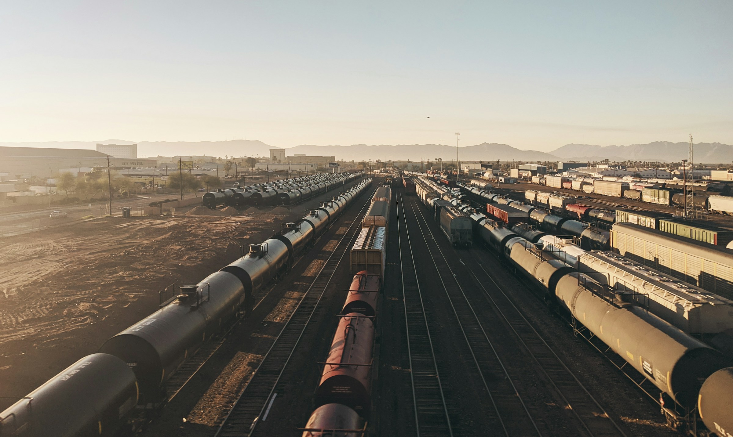 Railway yard at sunset with multiple train tracks and tank cars