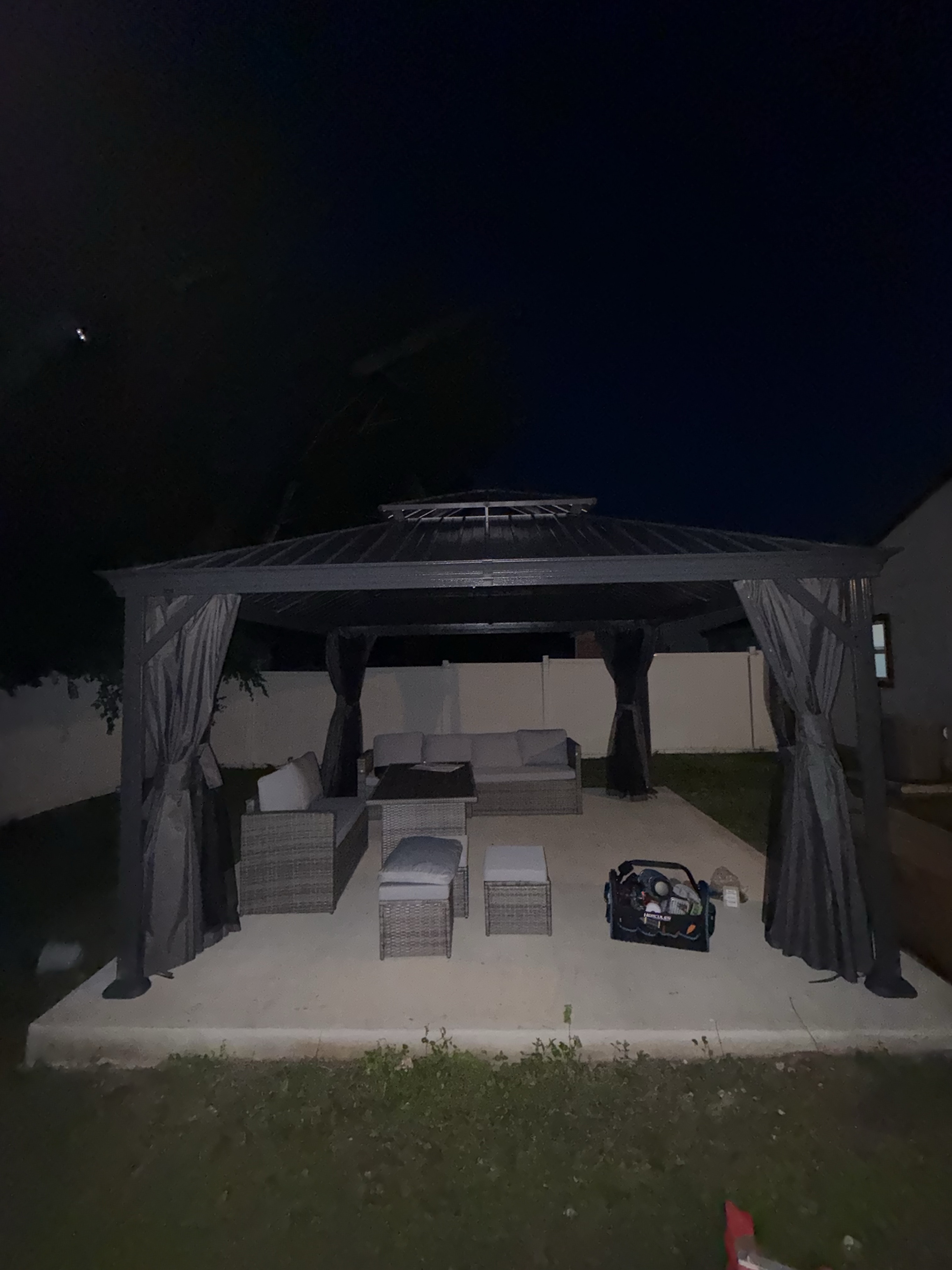Completed gazebo at night with furniture