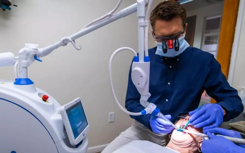 Dr. Schmidt using advanced laser dentistry technology on a patient