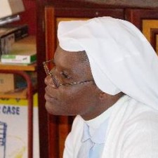 Porträt einer Ordensschwester mit weißem Habit und Brille