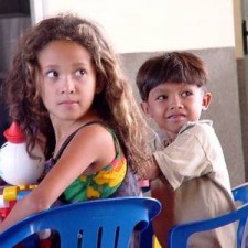 Mädchen und Junge auf blauen Stühlen