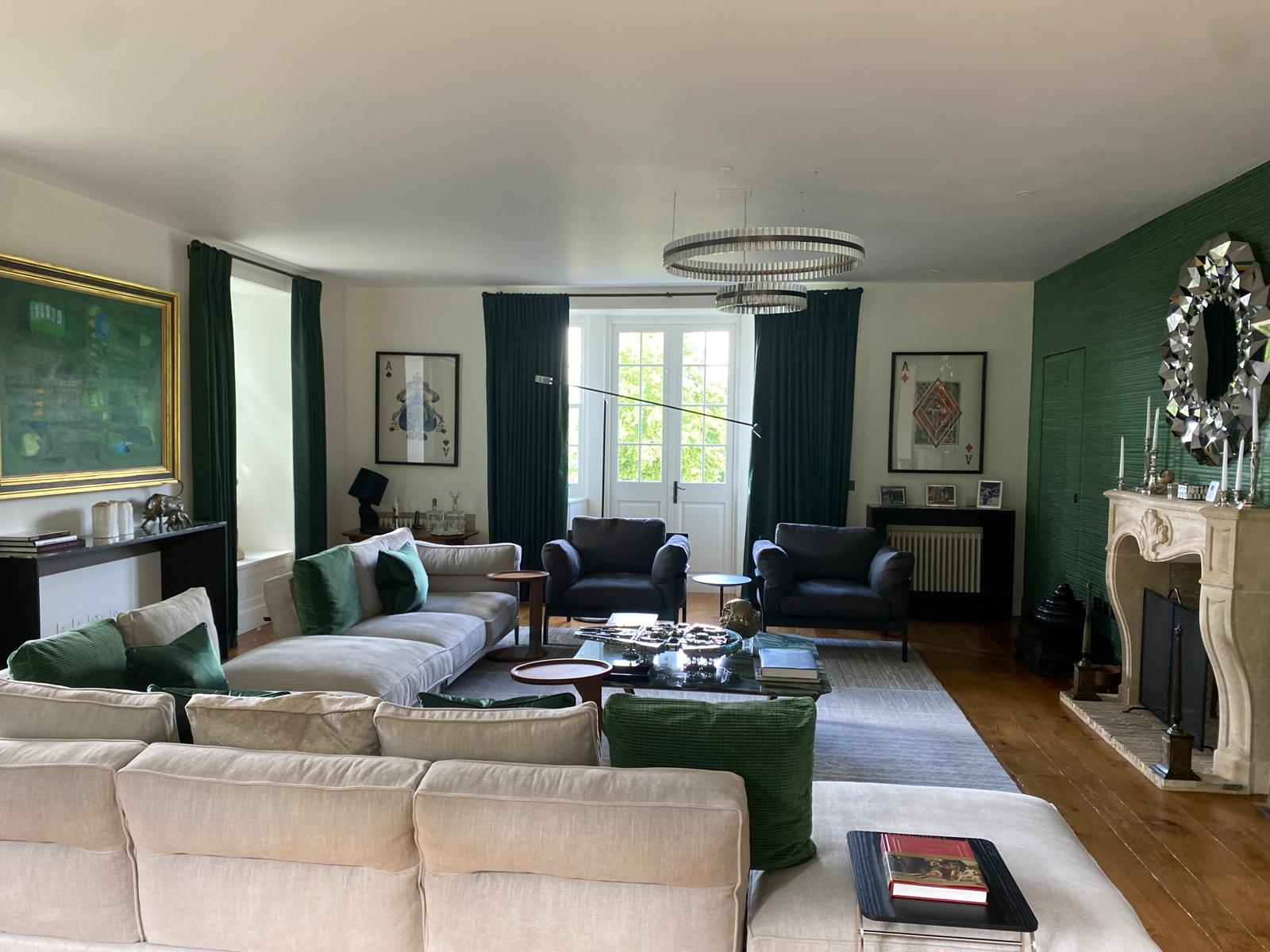 Living room with green grasscloth wallpaper and crystal chandelier