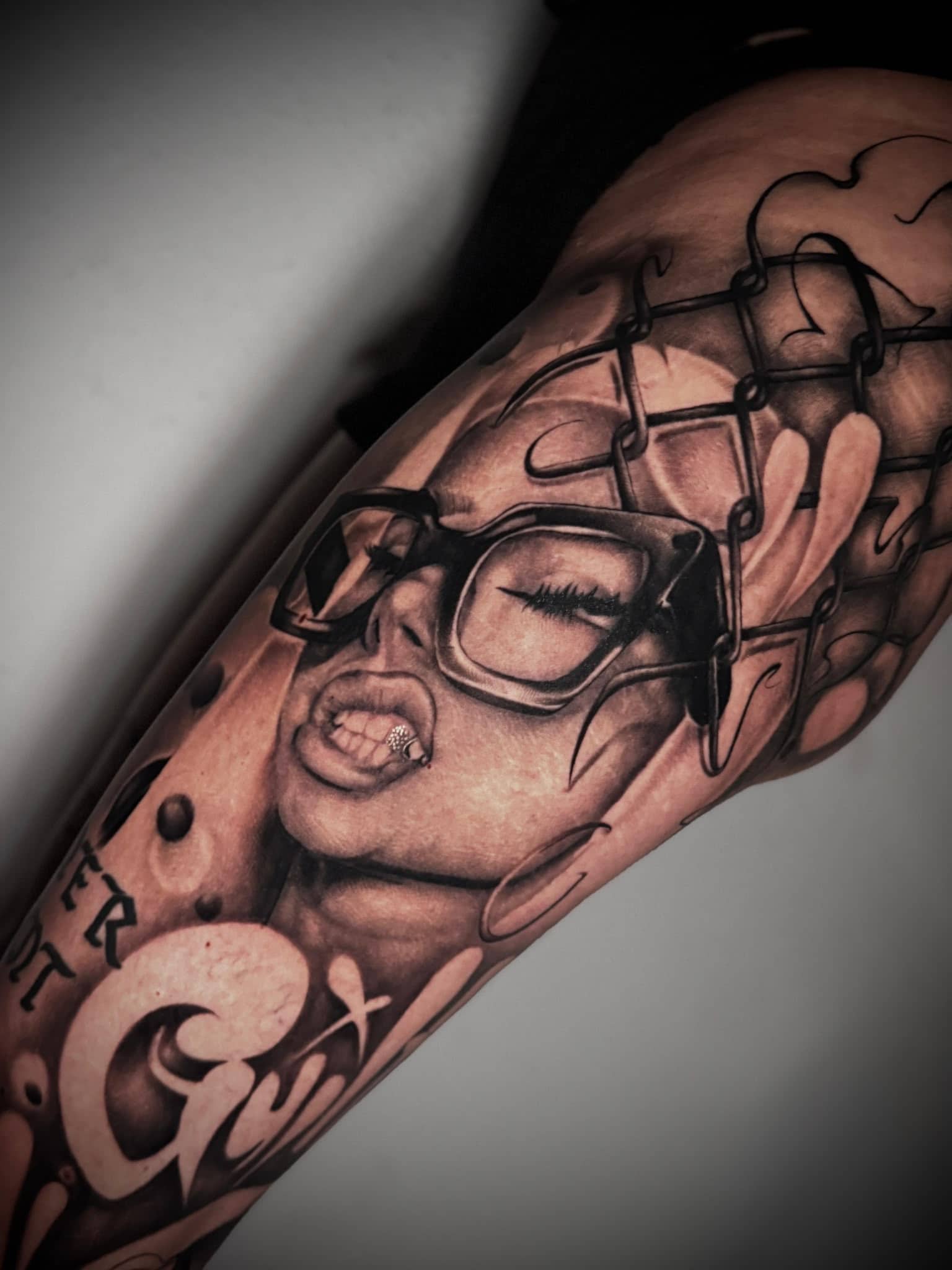 Black and Grey Frauengesicht mit Sonnenbrille und Angelhaken am Unterarm