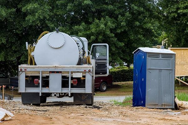 Portable restroom service truck and unit at a job site