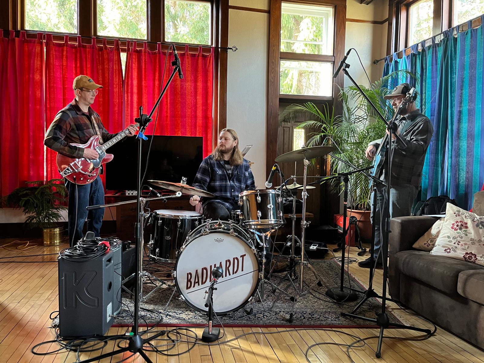 BADHARDT rehearsing in a living room with red curtains