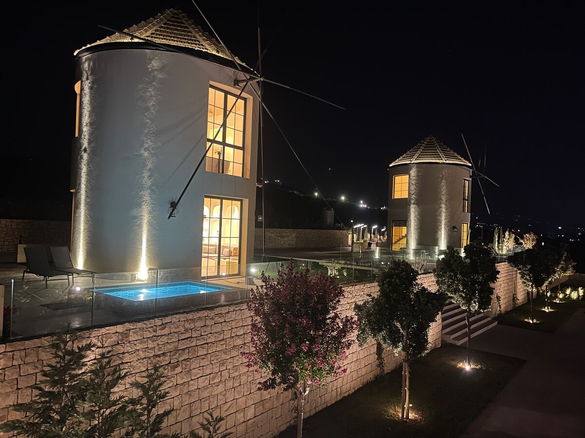 Both windmills illuminated at night