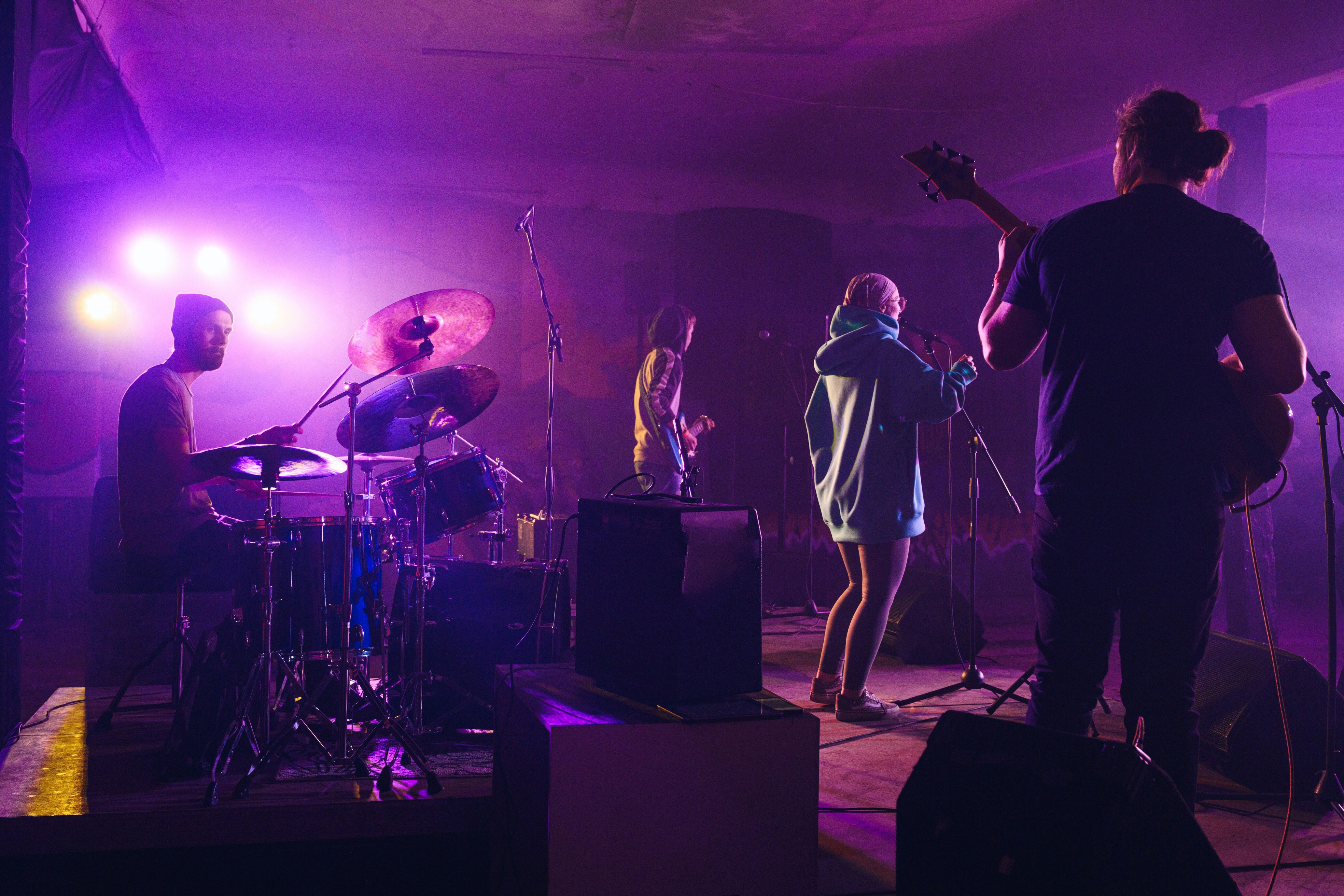 Band performing on stage under purple lighting