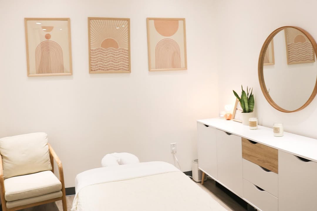 Bright, welcoming Zen Tara massage therapy treatment room with art prints, round mirror, and massage table