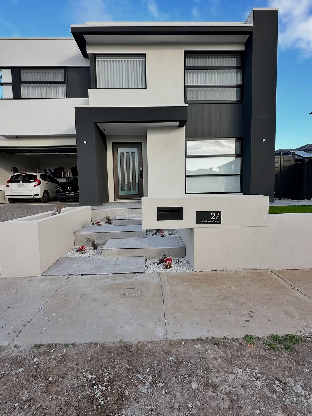 Modern property entrance with boundary wall and gate post