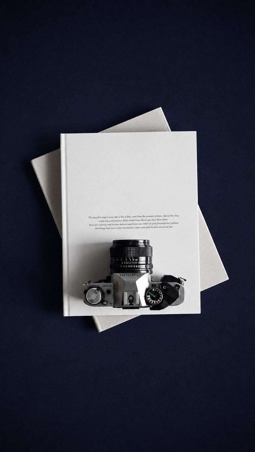 Camera on books against a dark navy background — Lumiere Studio Productions