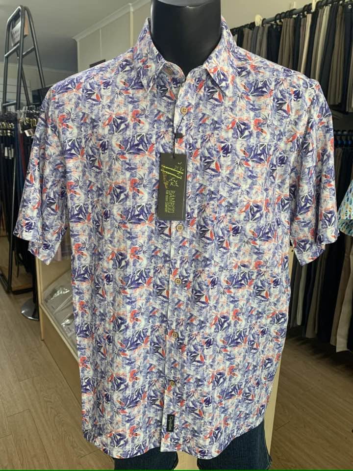 Short-sleeve shirt with a blue, coral and white leaf print on a display mannequin