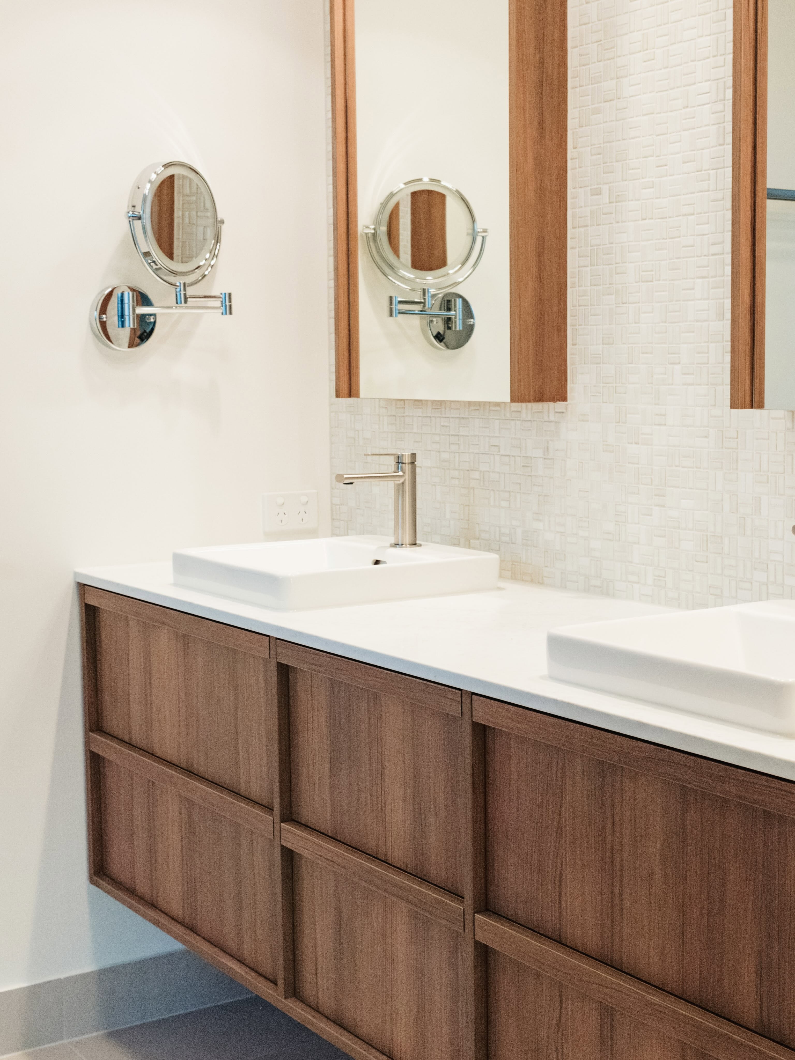 Timber bathroom vanity with double sinks and mounted mirrors
