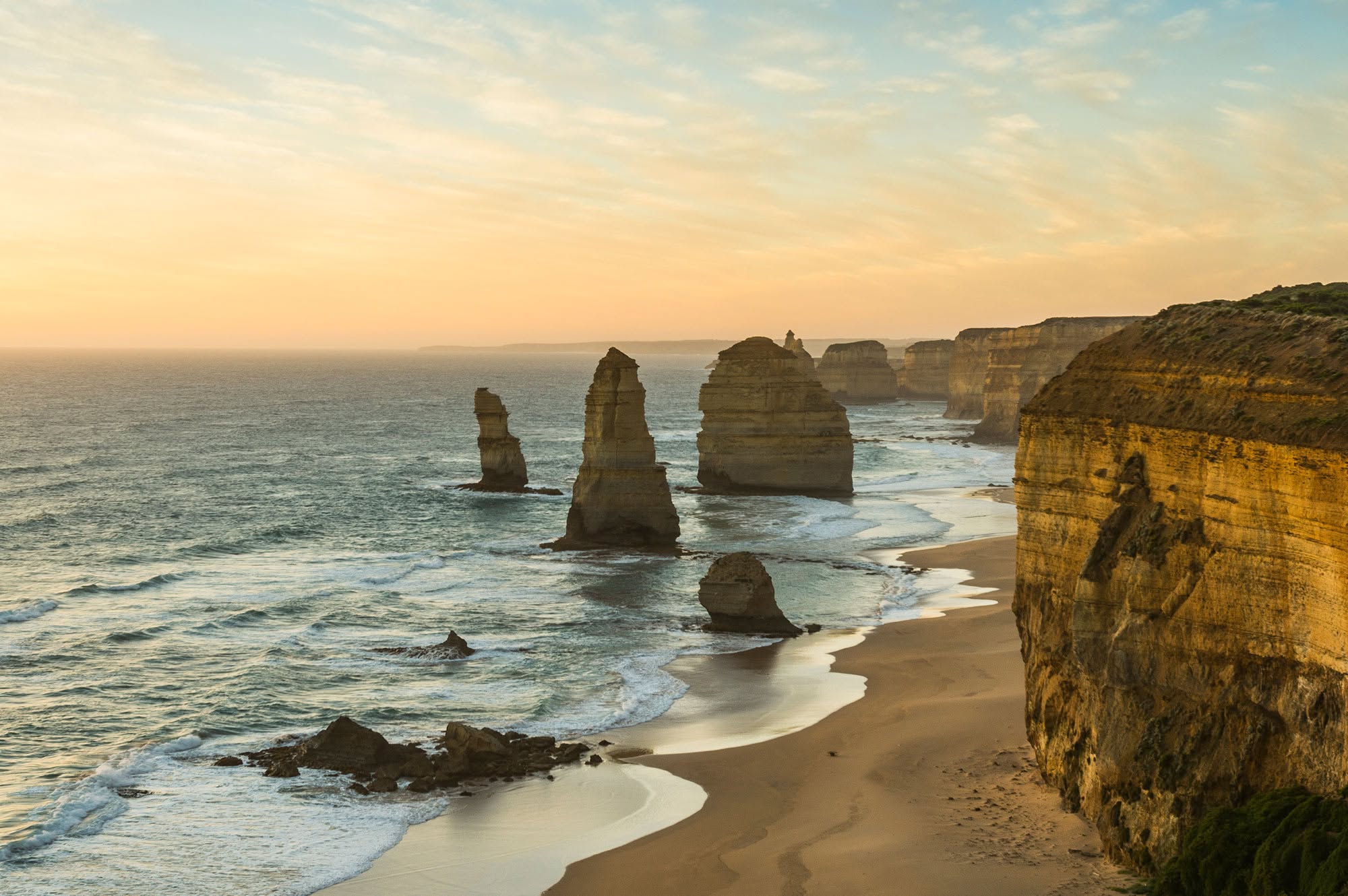 Aerial view of the Twelve Apostles limestone sea stacks along the Great Ocean Road at sunset, near Port Campbell