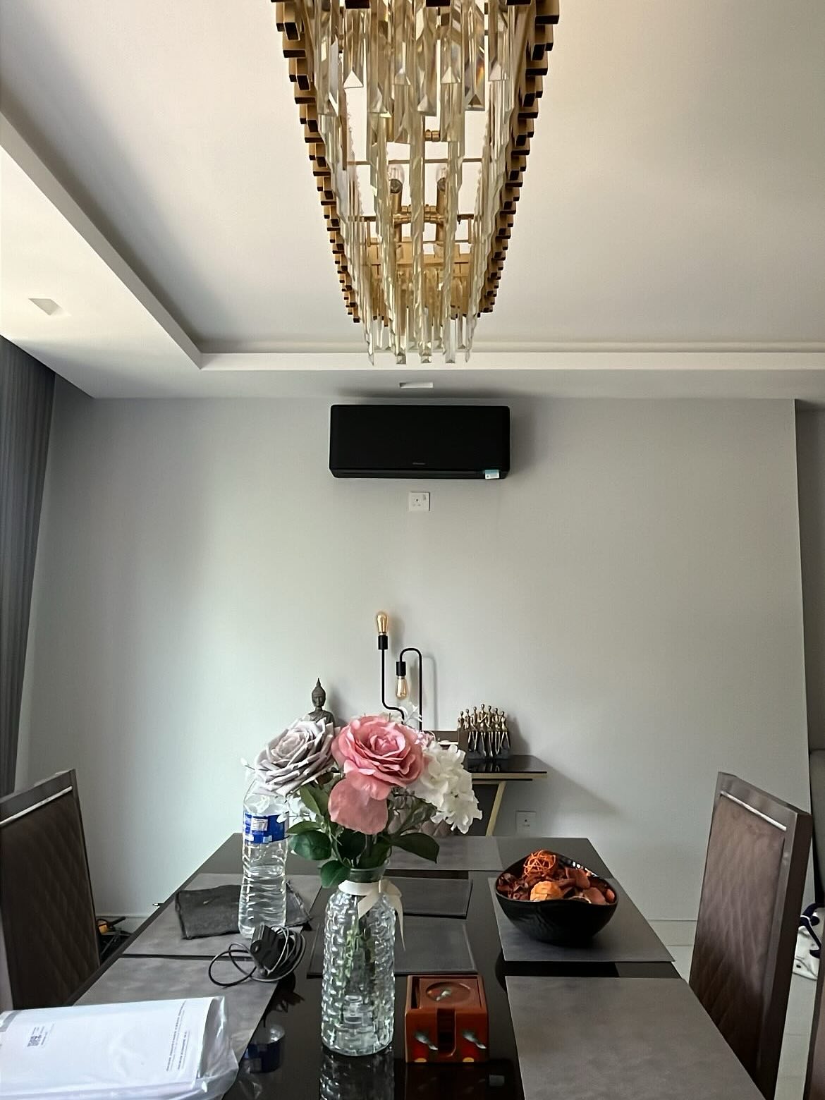 Black wall-mounted split system air conditioner installed in a modern dining room