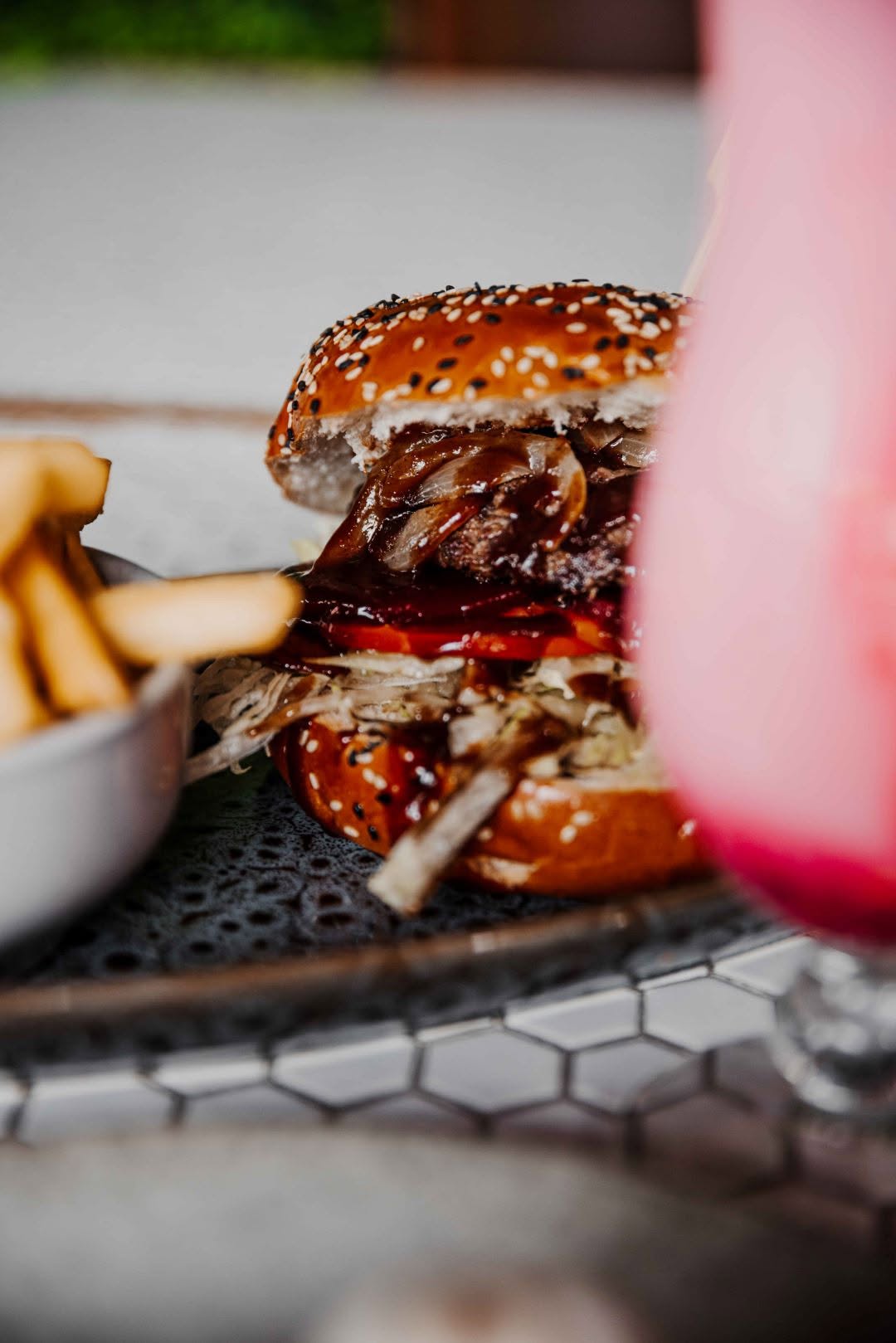 Close-up of a gourmet burger with sesame bun and fresh ingredients at Nunzios Garage Cafe