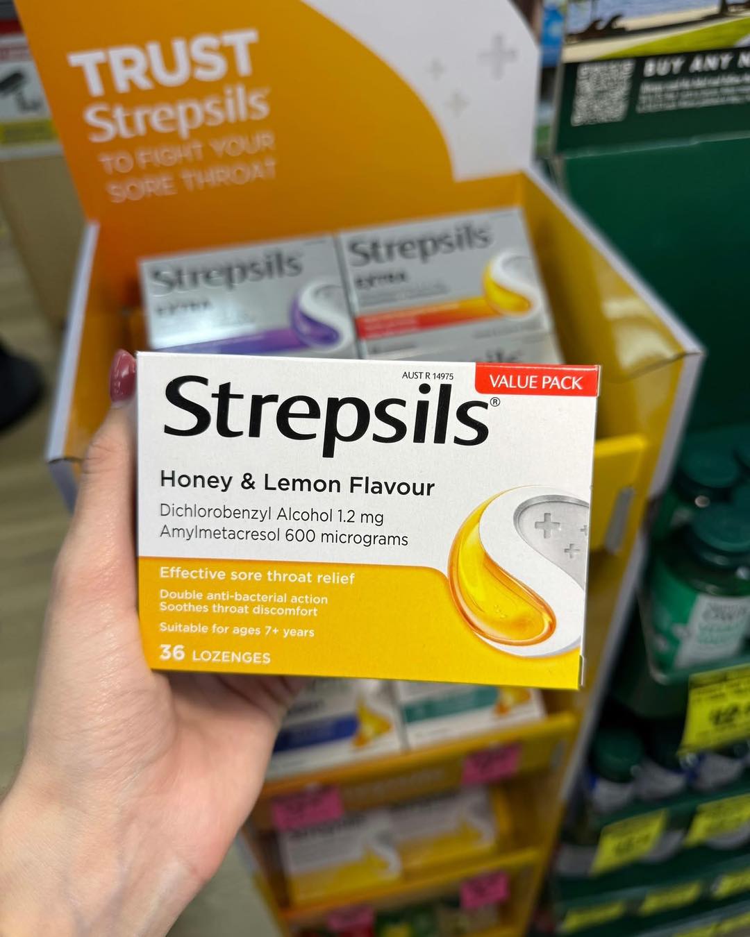 Box of Strepsils honey and lemon lozenges in front of a display stand