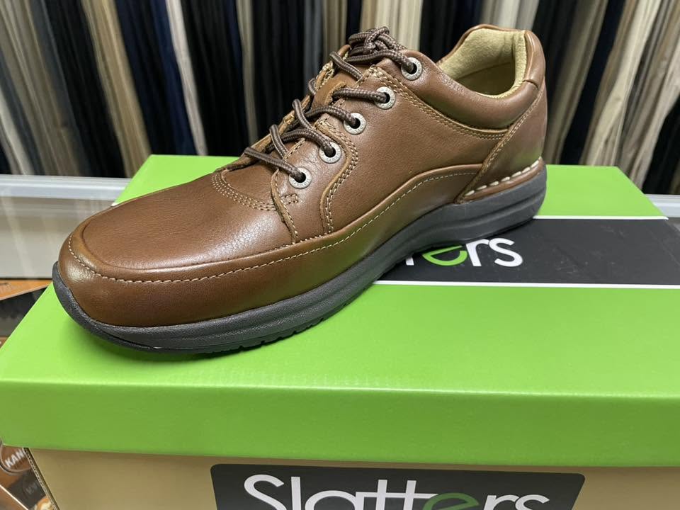 Brown leather lace-up shoe displayed on a shoe box