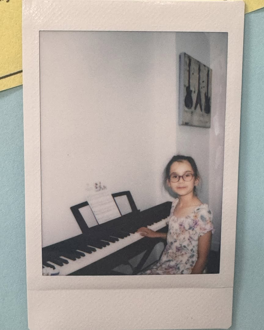 Child in glasses seated at a digital piano