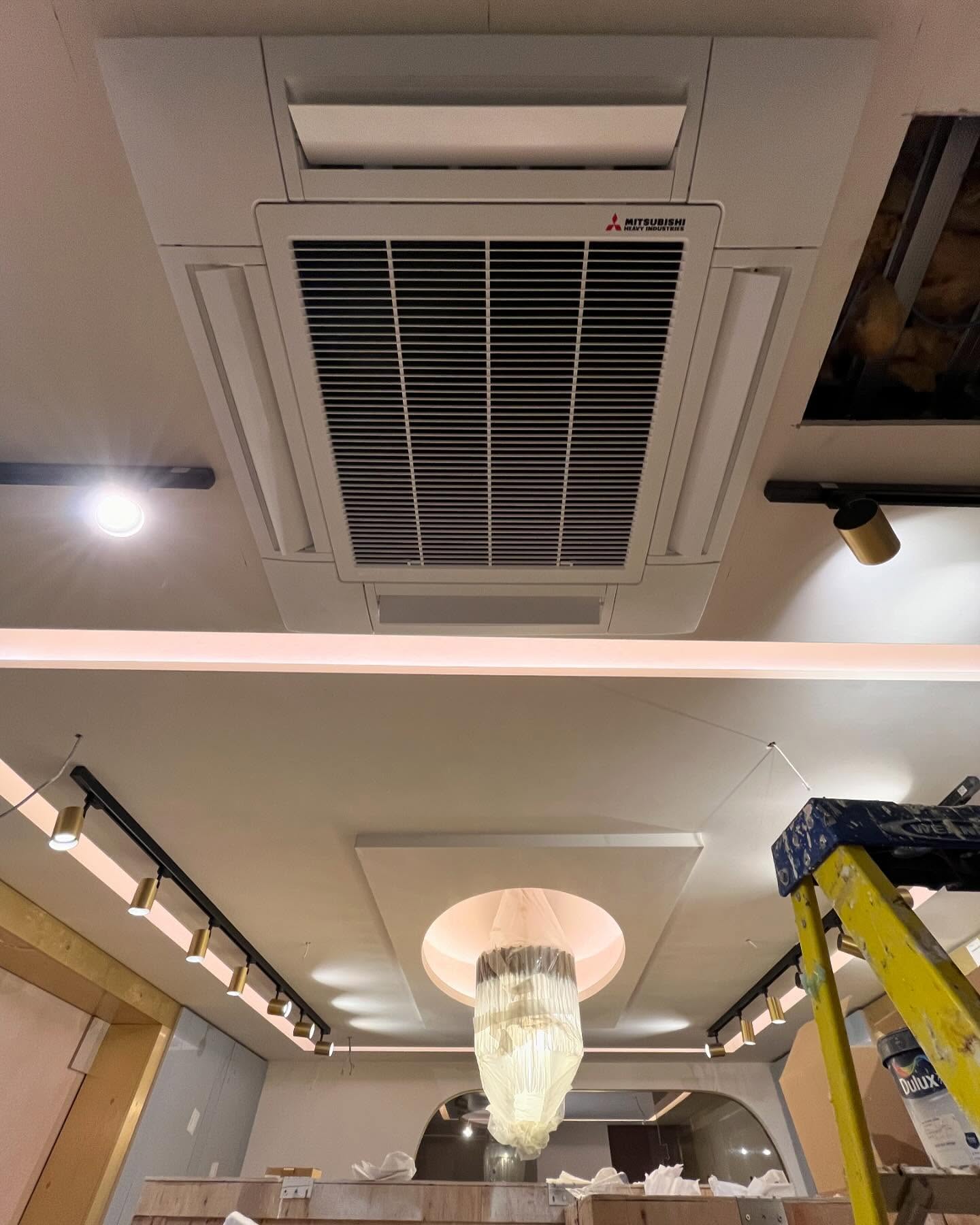 Ceiling-mounted cassette air conditioning unit installed in a commercial interior space