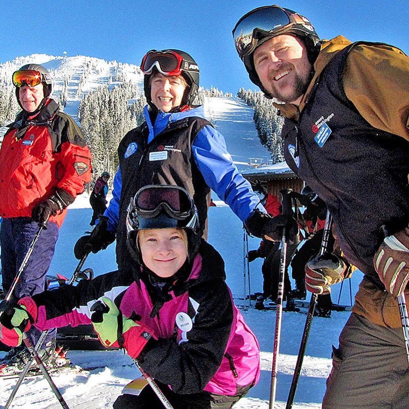 Group of adaptive skiers on a snowy mountain, demonstrating inclusive recreational activities