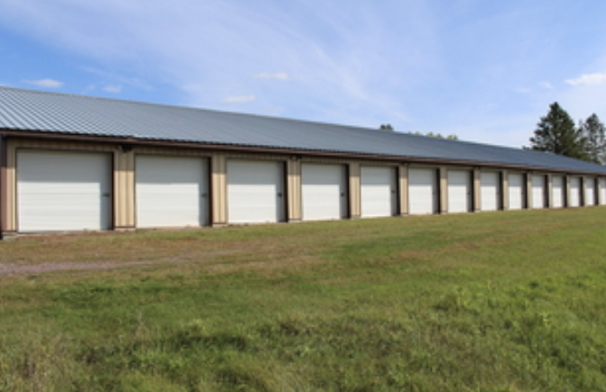 Storage units row with green grass foreground and blue sky