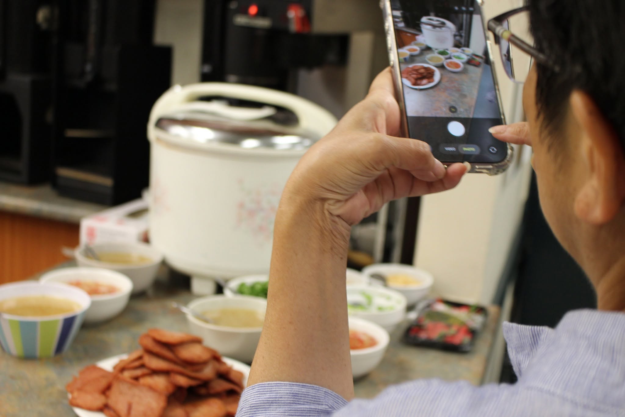 Community member photographing cultural food at a cooking program