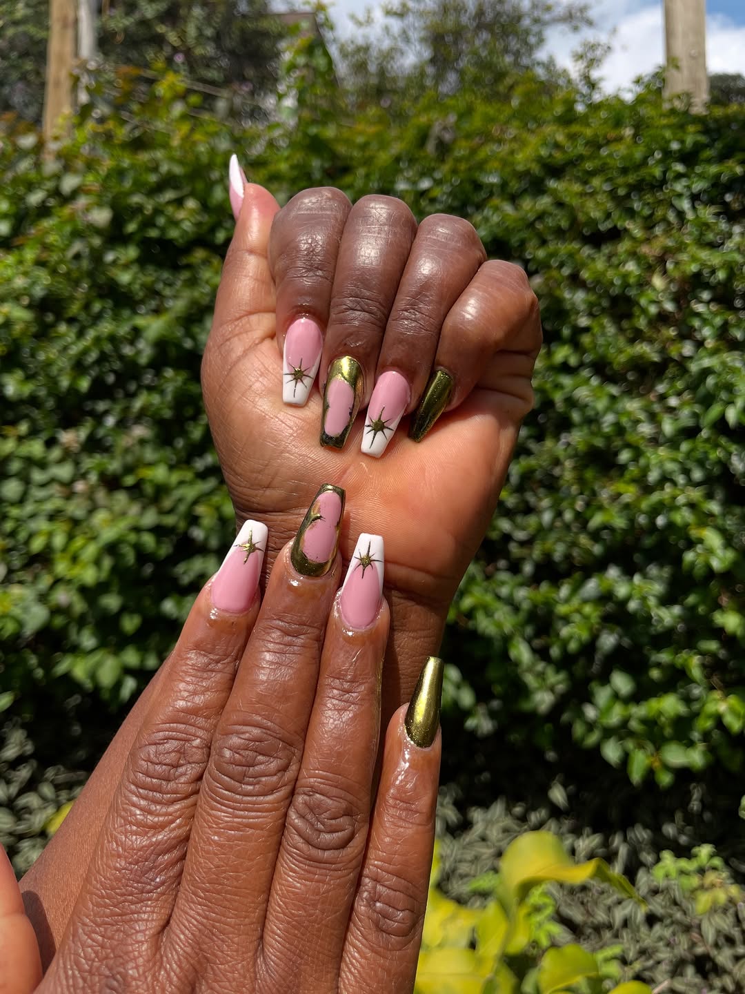 Pink and gold chrome nail art with starburst design