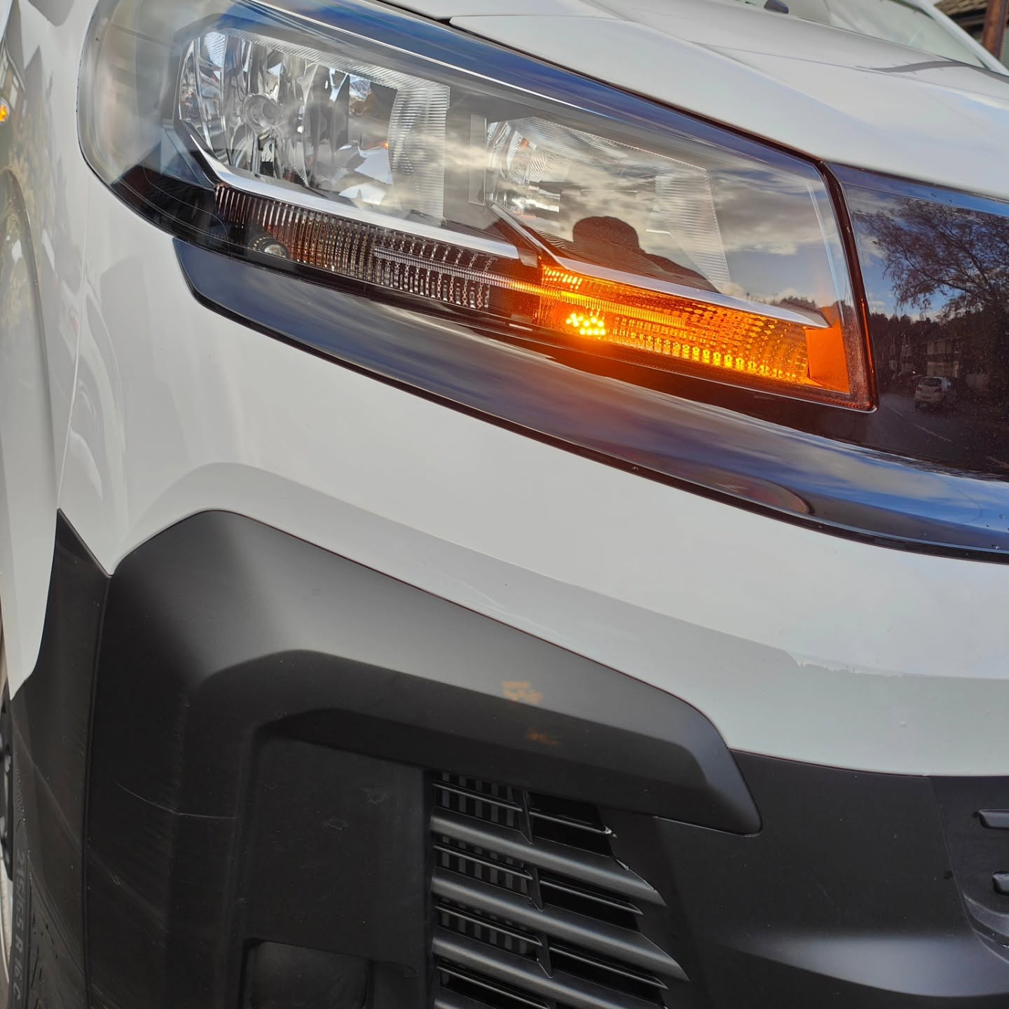 Close-up of a vehicle headlight with amber indicator — maintenance and servicing