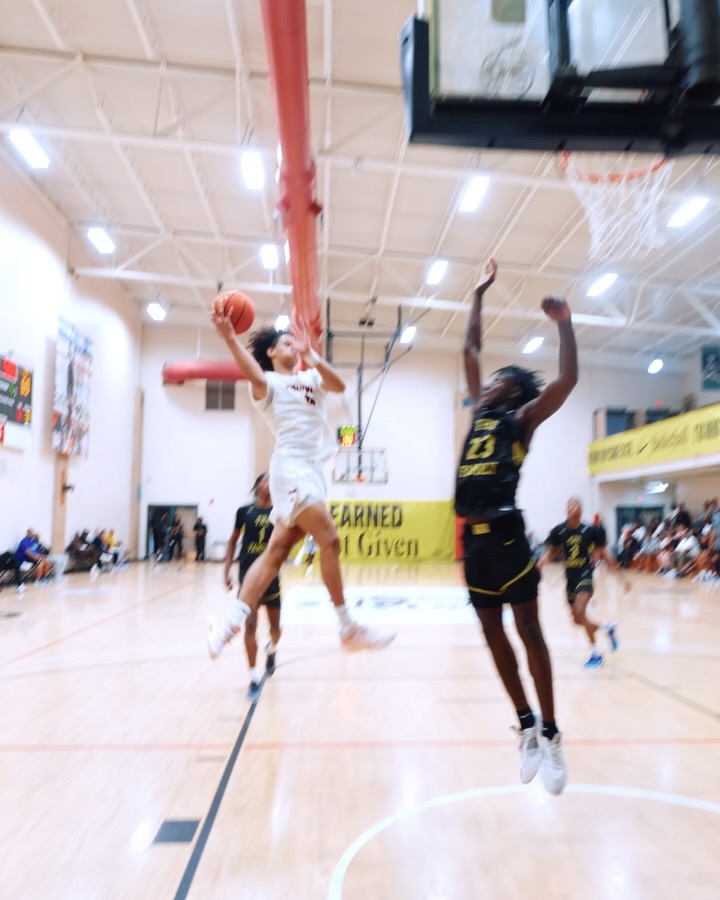 Basketball player going up for a layup in a competitive game