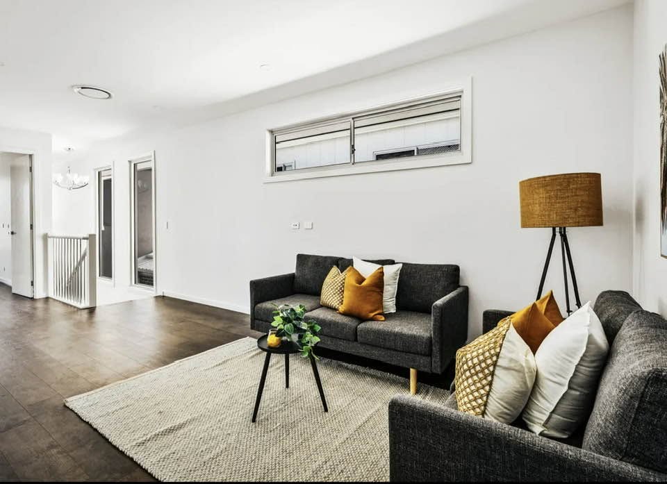 Upstairs living area with grey sofas, dark timber flooring and a feature floor lamp