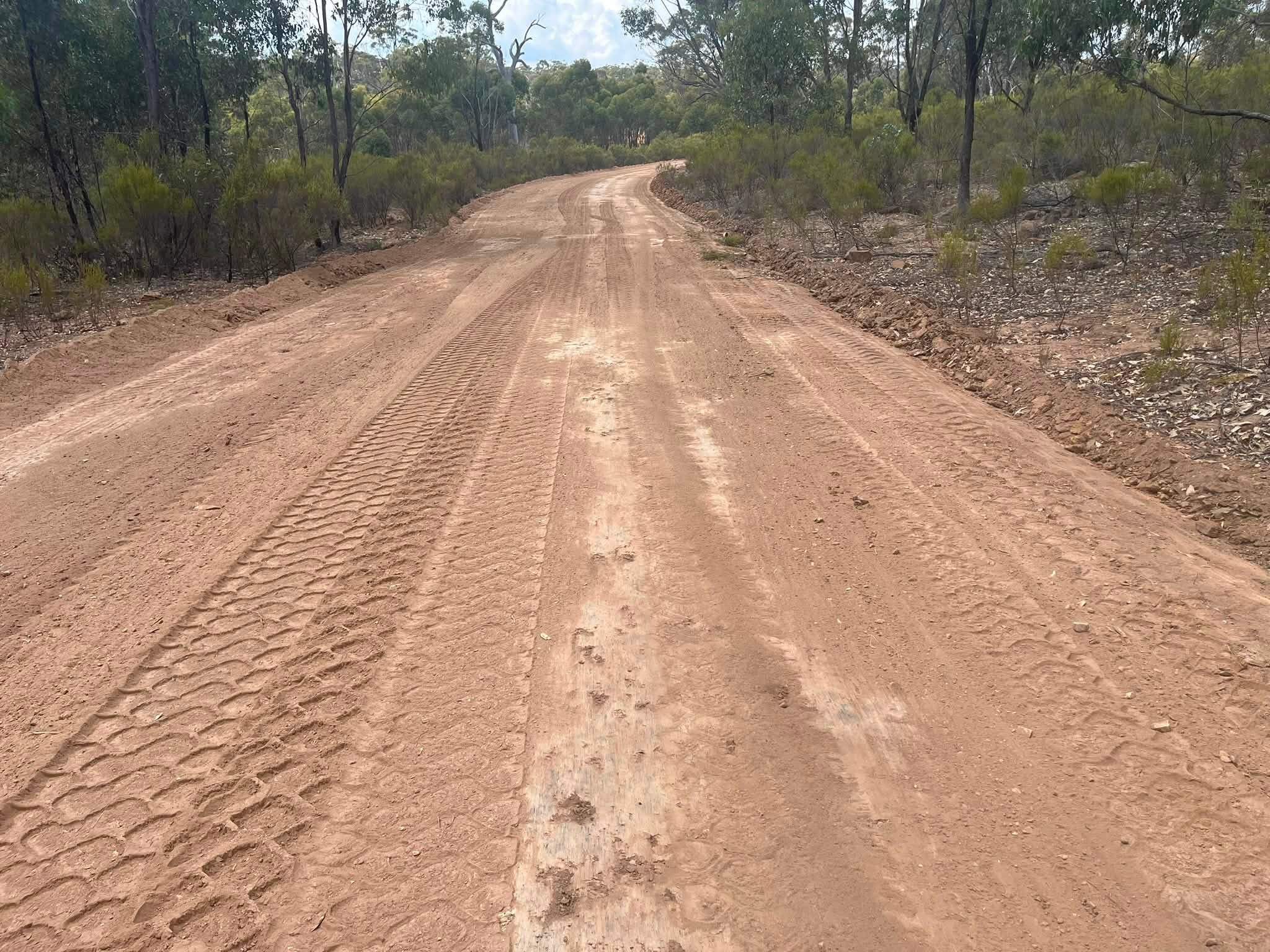 Completed rural access track winding through eucalyptus bush