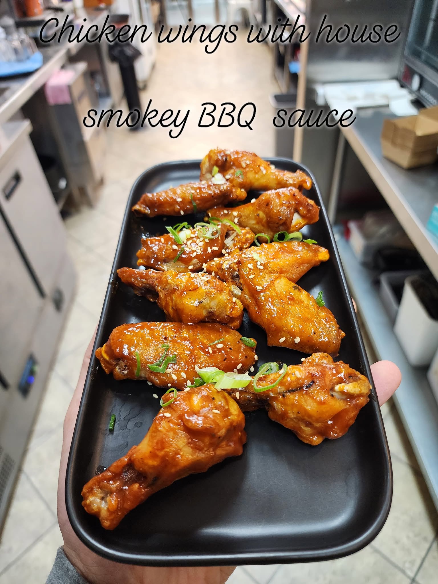 Chicken wings glazed in house smokey BBQ sauce, garnished with spring onions and sesame seeds