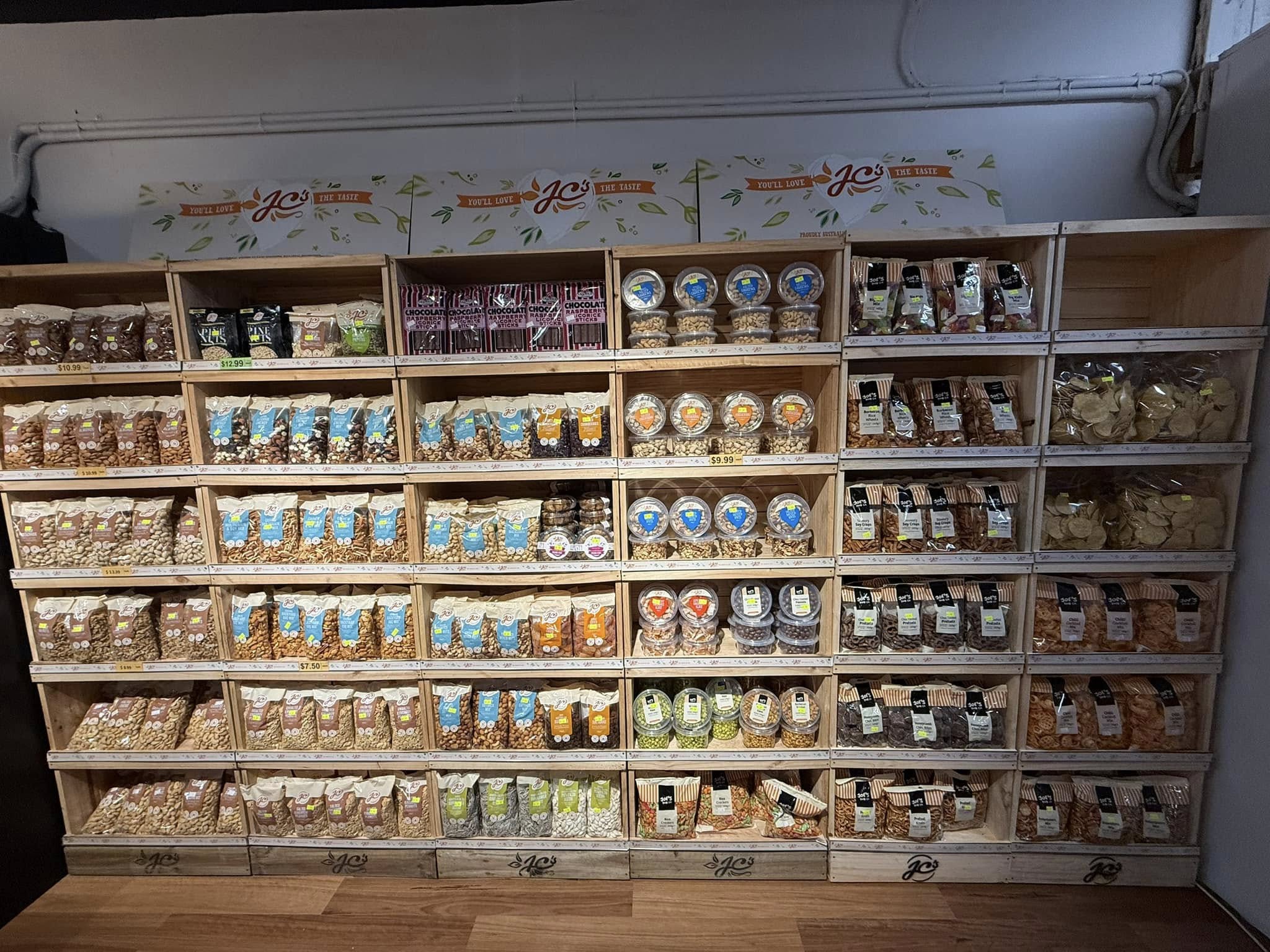 Wall of specialty nuts and snack products in wooden cubby shelving