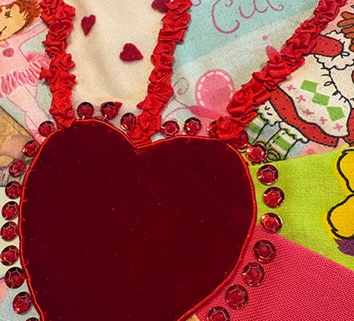 Decorative textile heart artwork with red embellishments