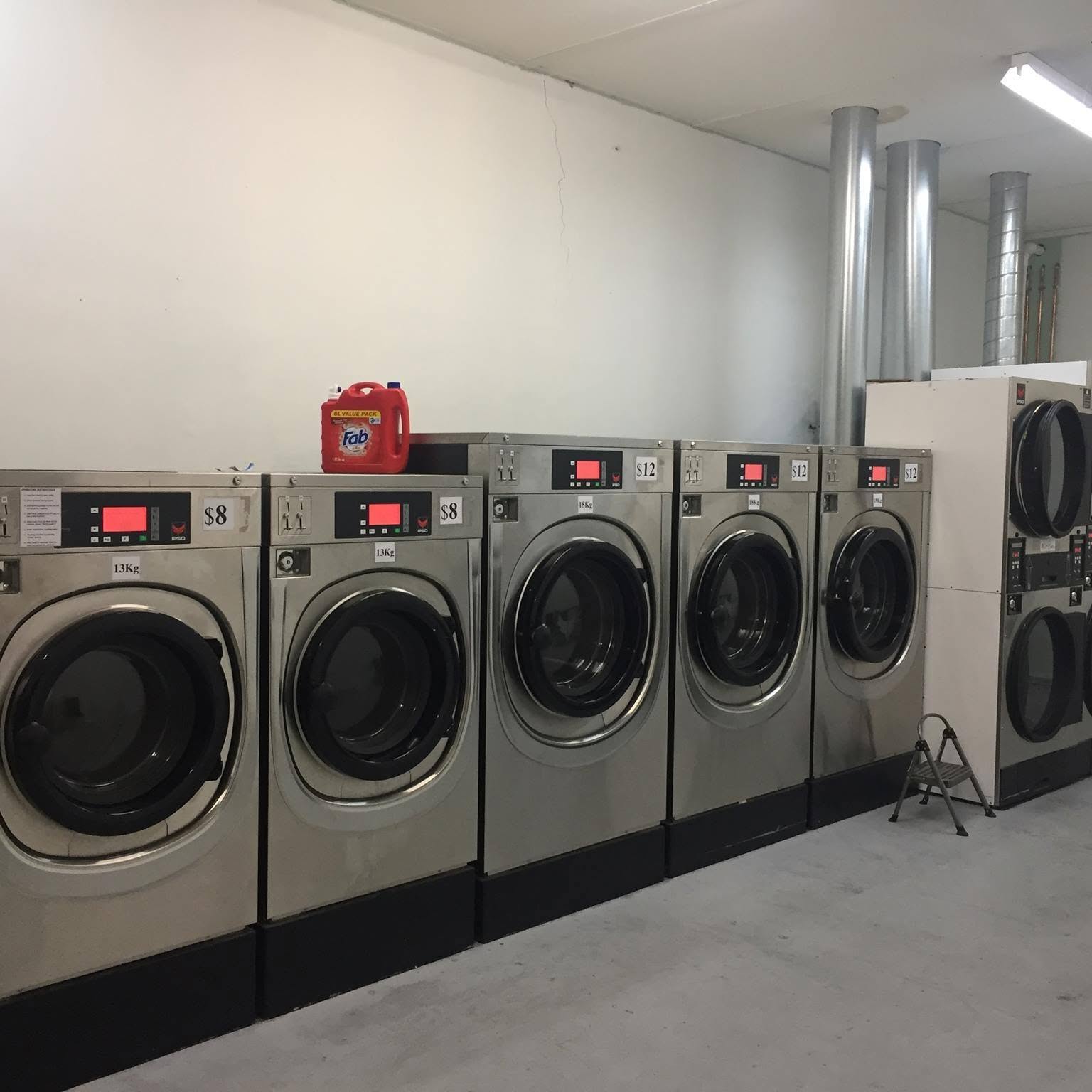 Row of stainless steel coin-operated washing machines