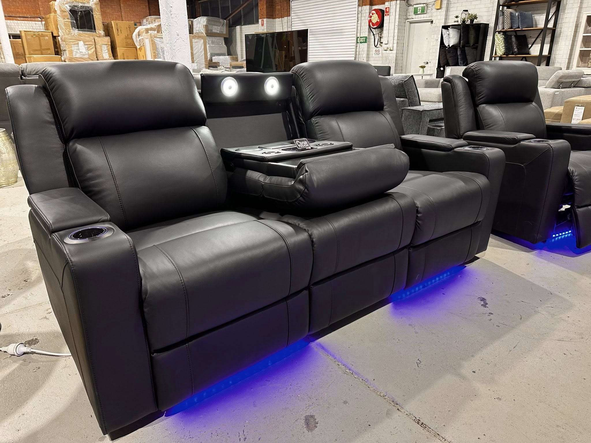 Black leather recliner sofa with cup holders and blue under-lighting