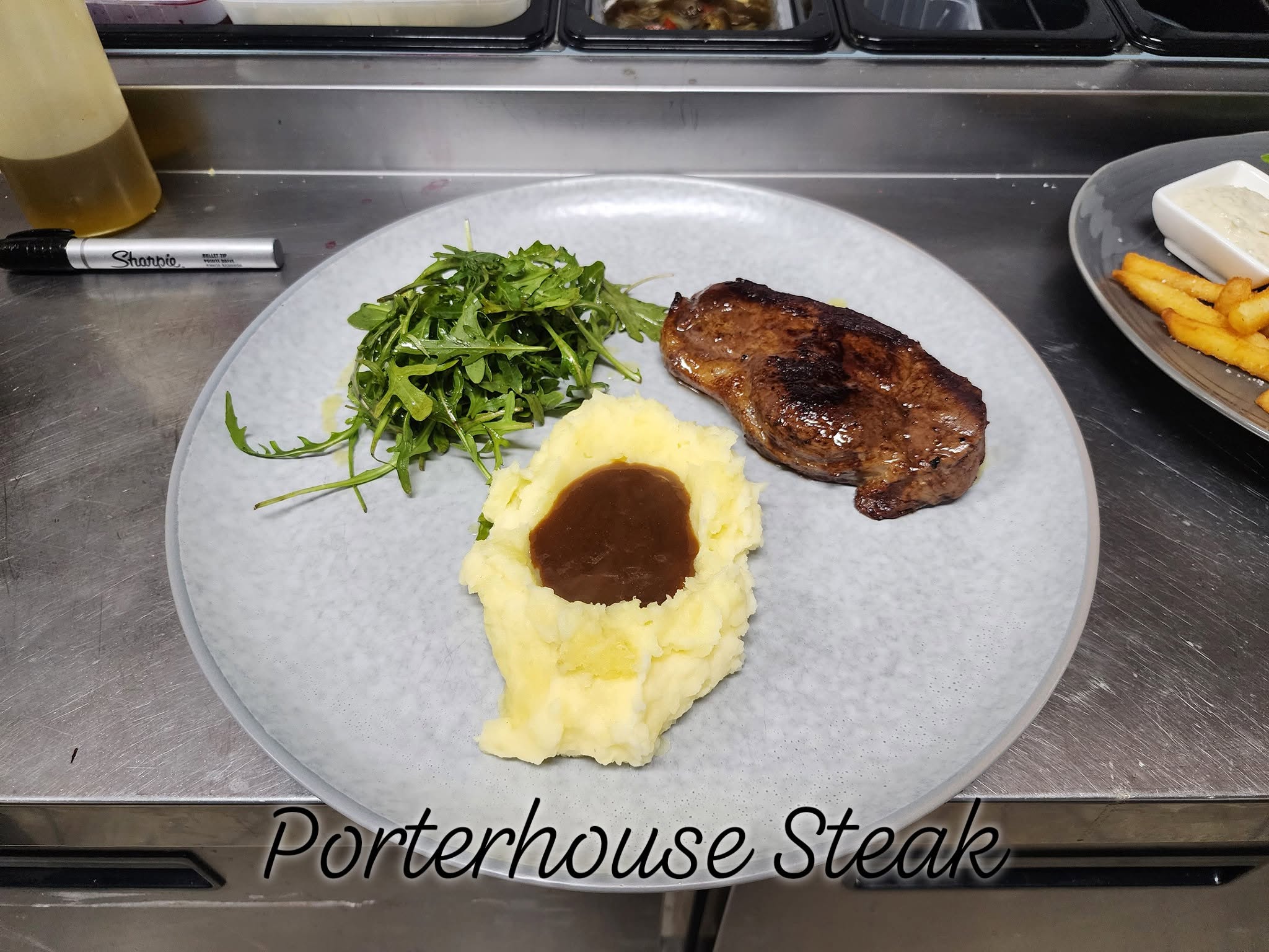 Grilled porterhouse steak served with mashed potato, gravy and a rocket salad