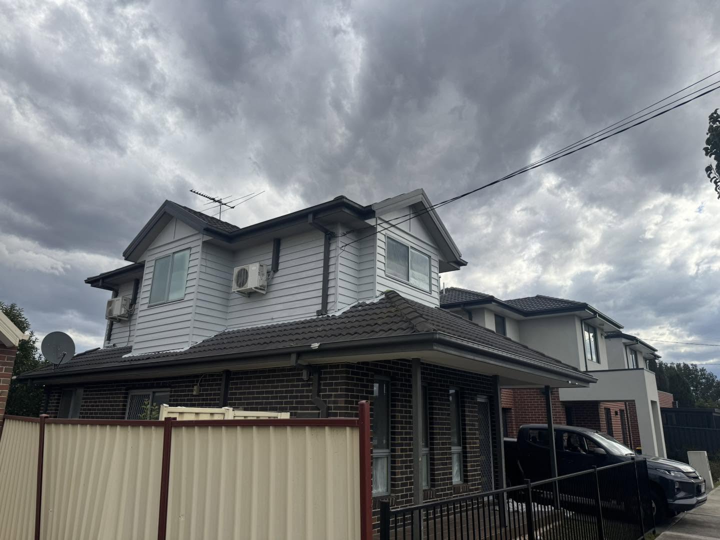 Exterior of two-storey white weatherboard and brick home