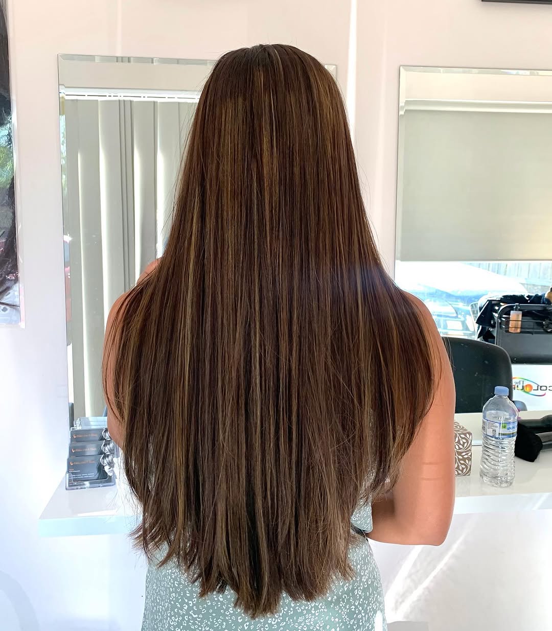 Glossy brunette hair with caramel highlights — highlights service at NAIDAS HAIRSALON