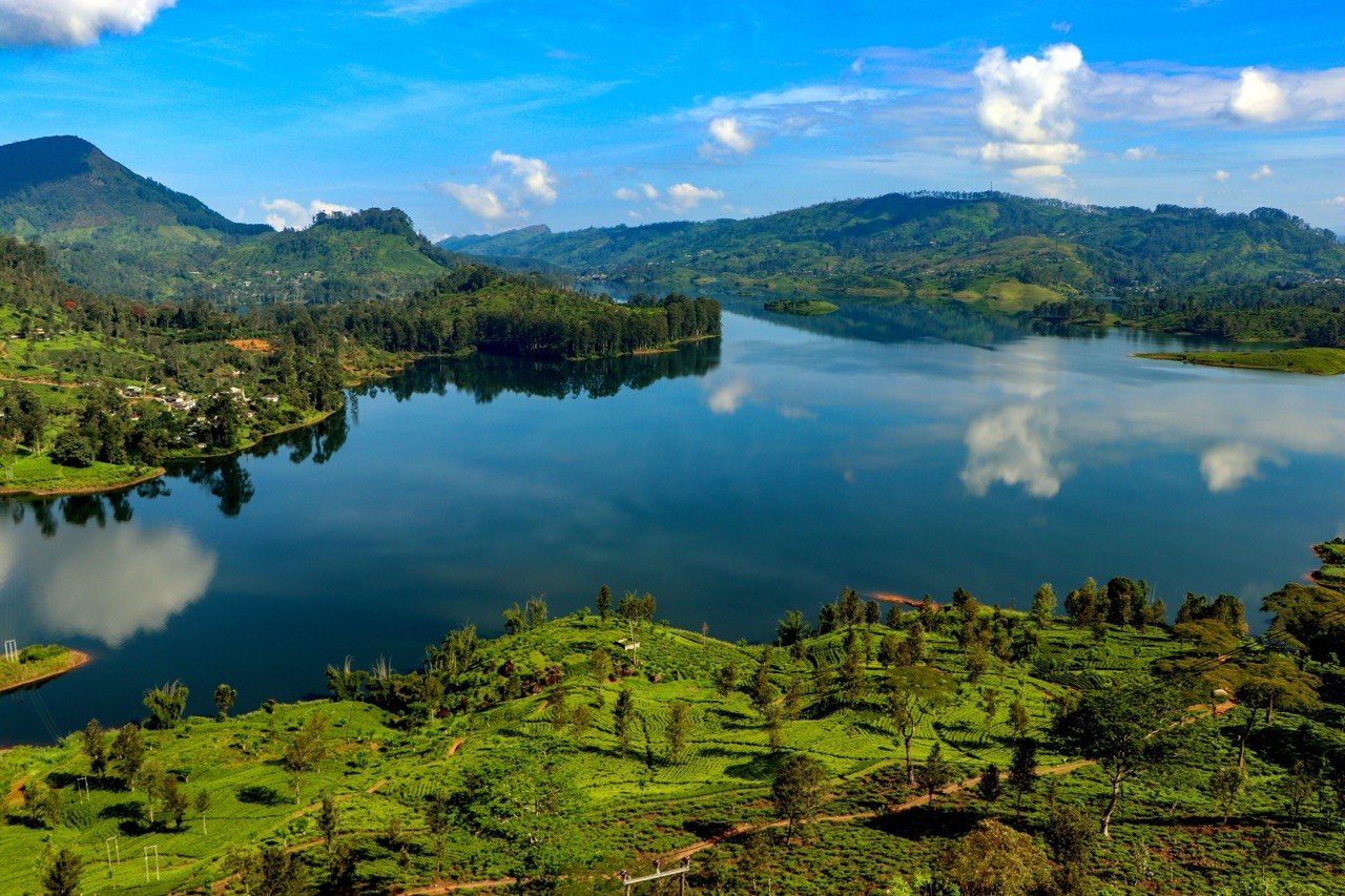 Jezero mezi zelenými kopci a čajovými plantážemi na Srí Lance