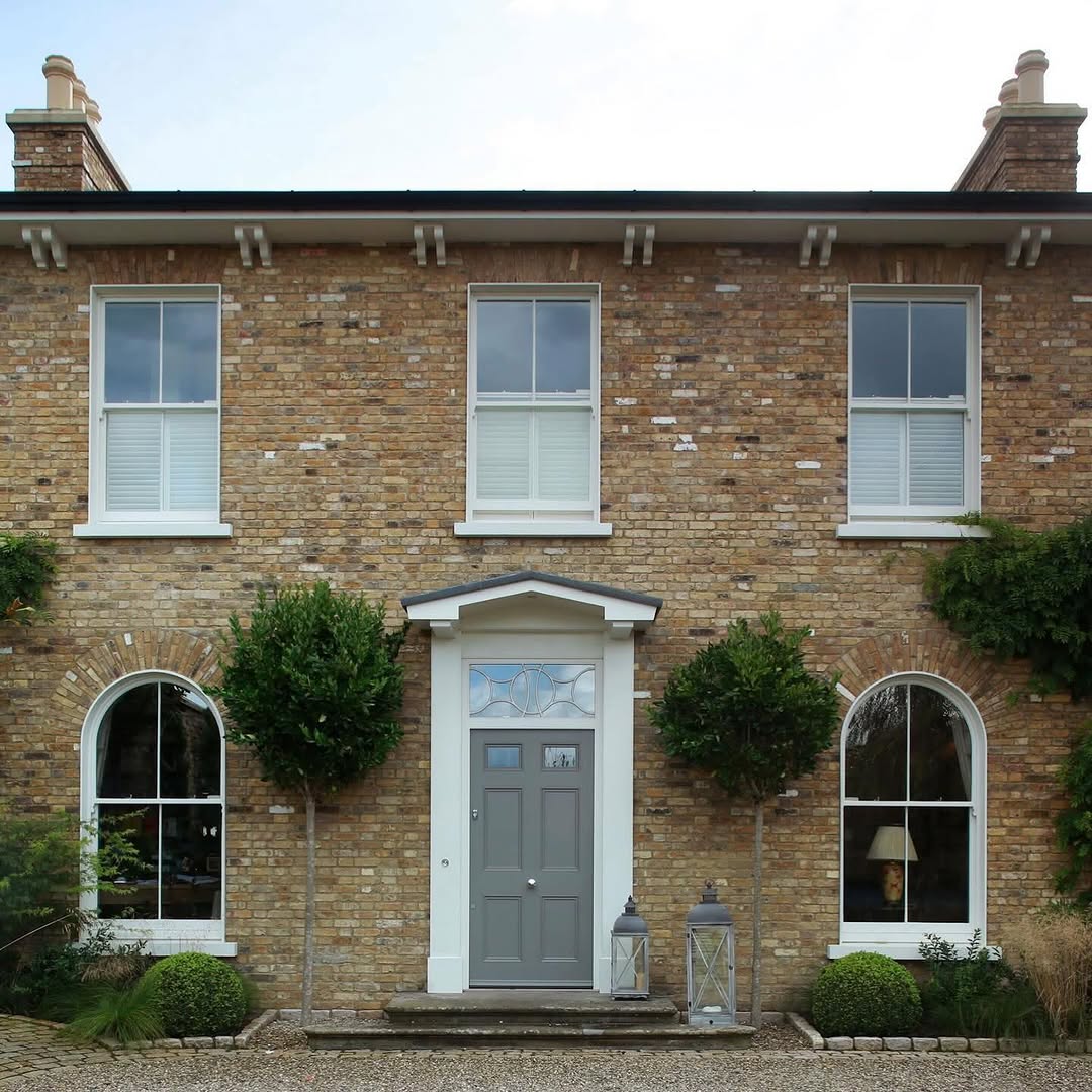 Classic brick facade with arched windows and period details — a style of architecture where salvaged materials come into their own