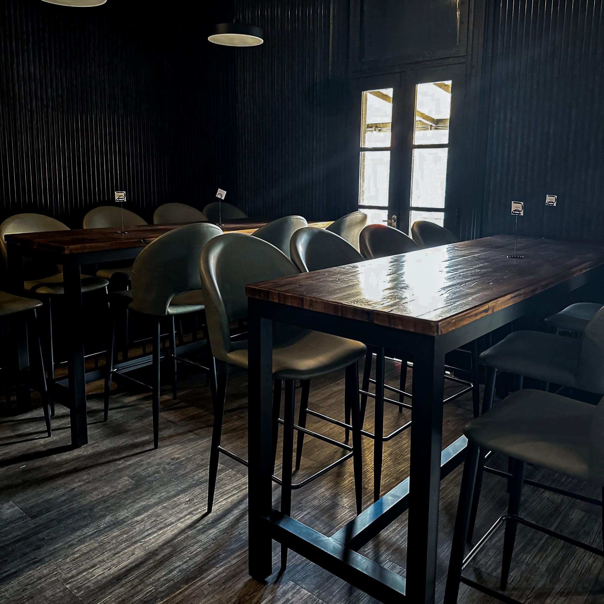Dining room at Second Floor Grill & Bar with timber tables, high stools and soft light from the balcony doors