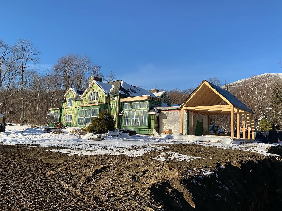 Luxury custom home under construction with blue sky backdrop
