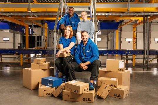 Equipo de empleados Goil GLS posando con cajas
