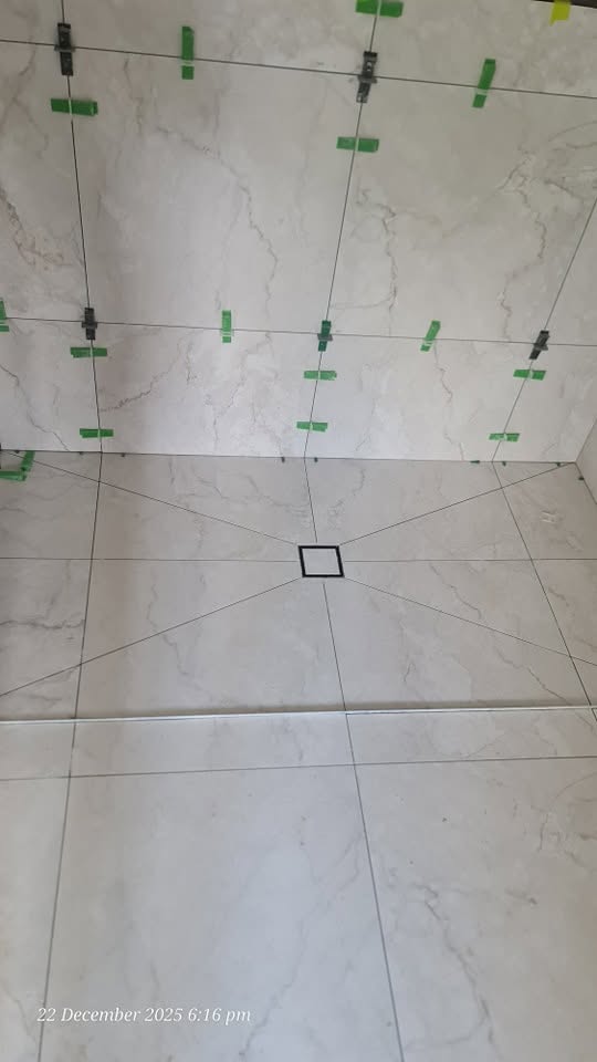 Shower floor tiling with central drain and precise tile alignment