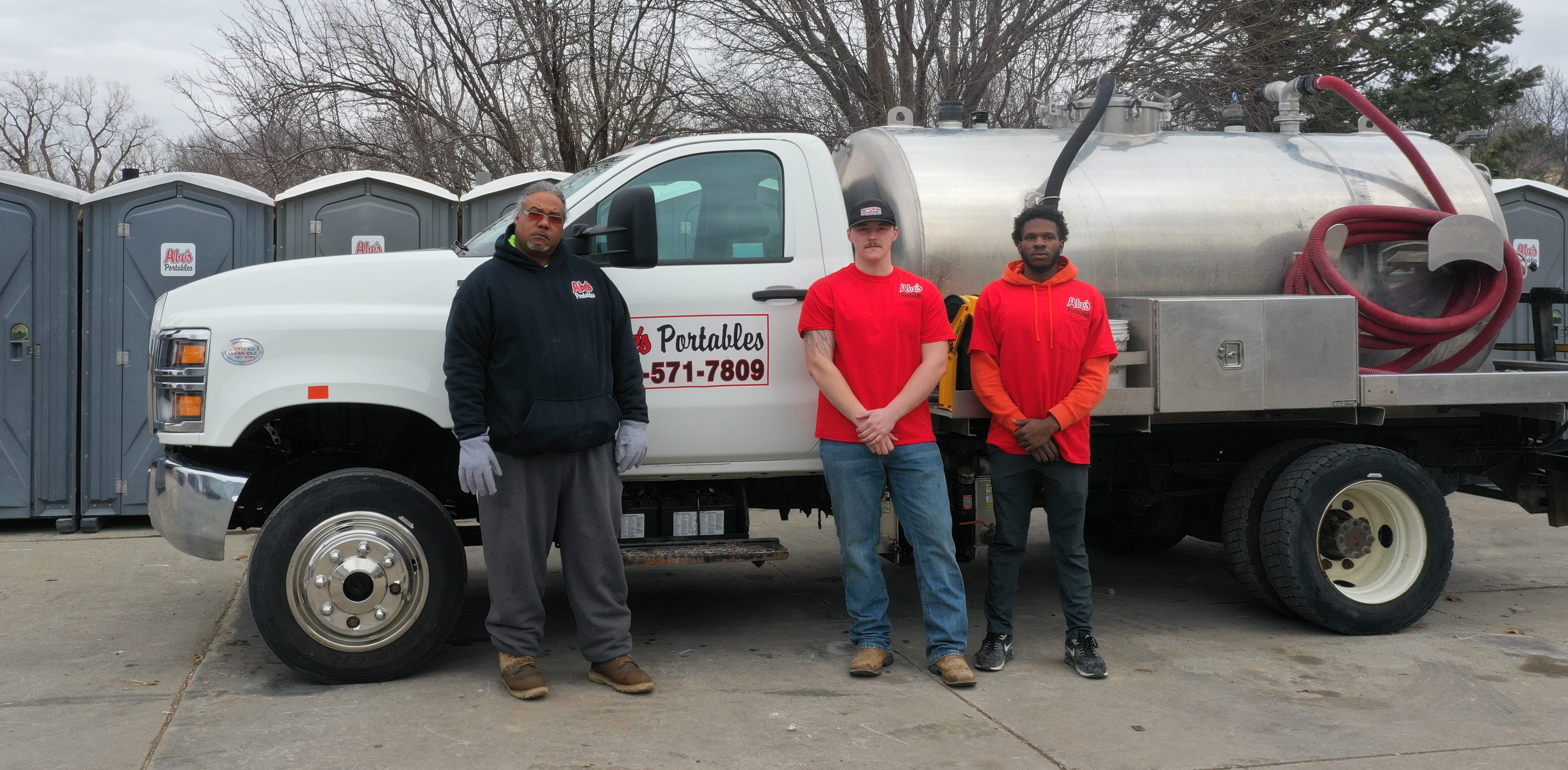 Abe's Portables crew and service truck in front of their portable unit fleet