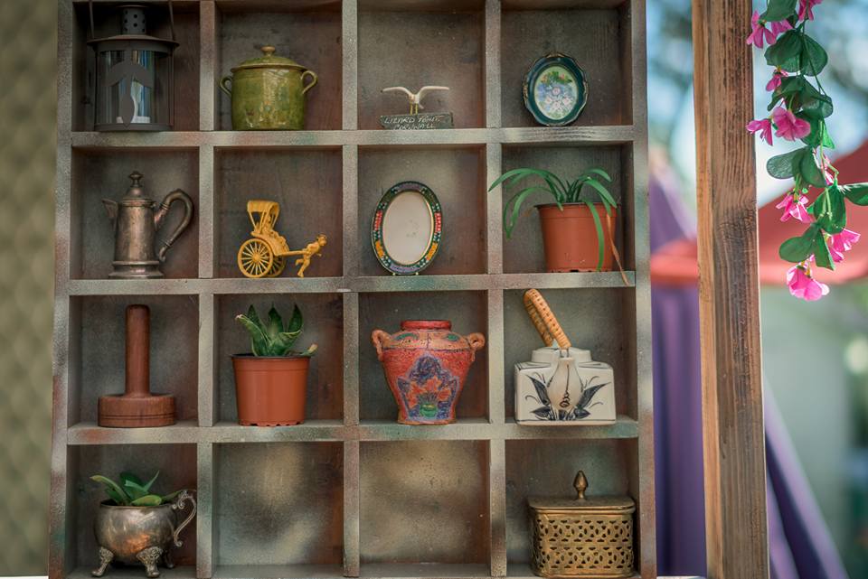 Rustic wooden display cabinet with vintage trinkets, small plants and ceramics decorating the Monday Morning Cafe