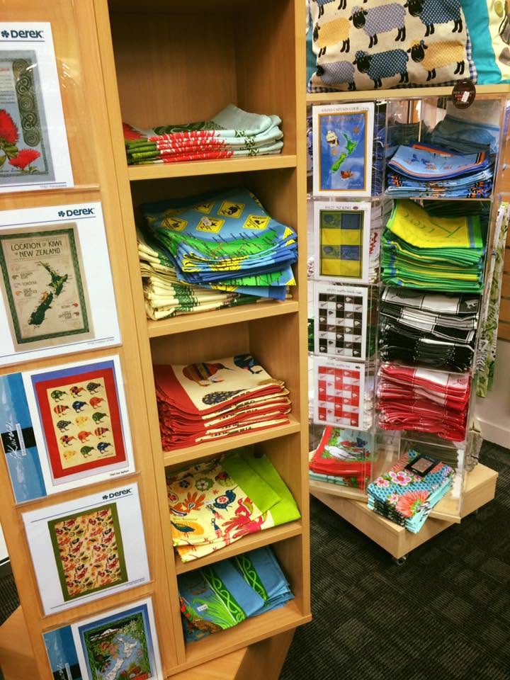 Colourful Australian souvenir merchandise including tea towels and gifts displayed on wooden shelving